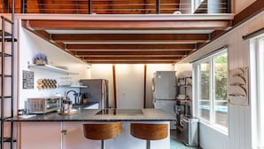 Eine moderne Küche mit einer zentralen Kochinsel, Barhocker und einem eingebauten Backofen.