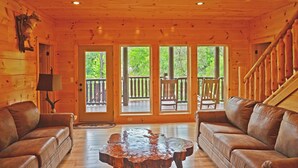 A wooden cabin interior with two leather sofas, a wooden coffee table, and a wooden ceiling with recessed lighting. - Luxury 4 King Suites, 4 Bath Log Cabin Close to Town & Trolley (Gatlinburg)