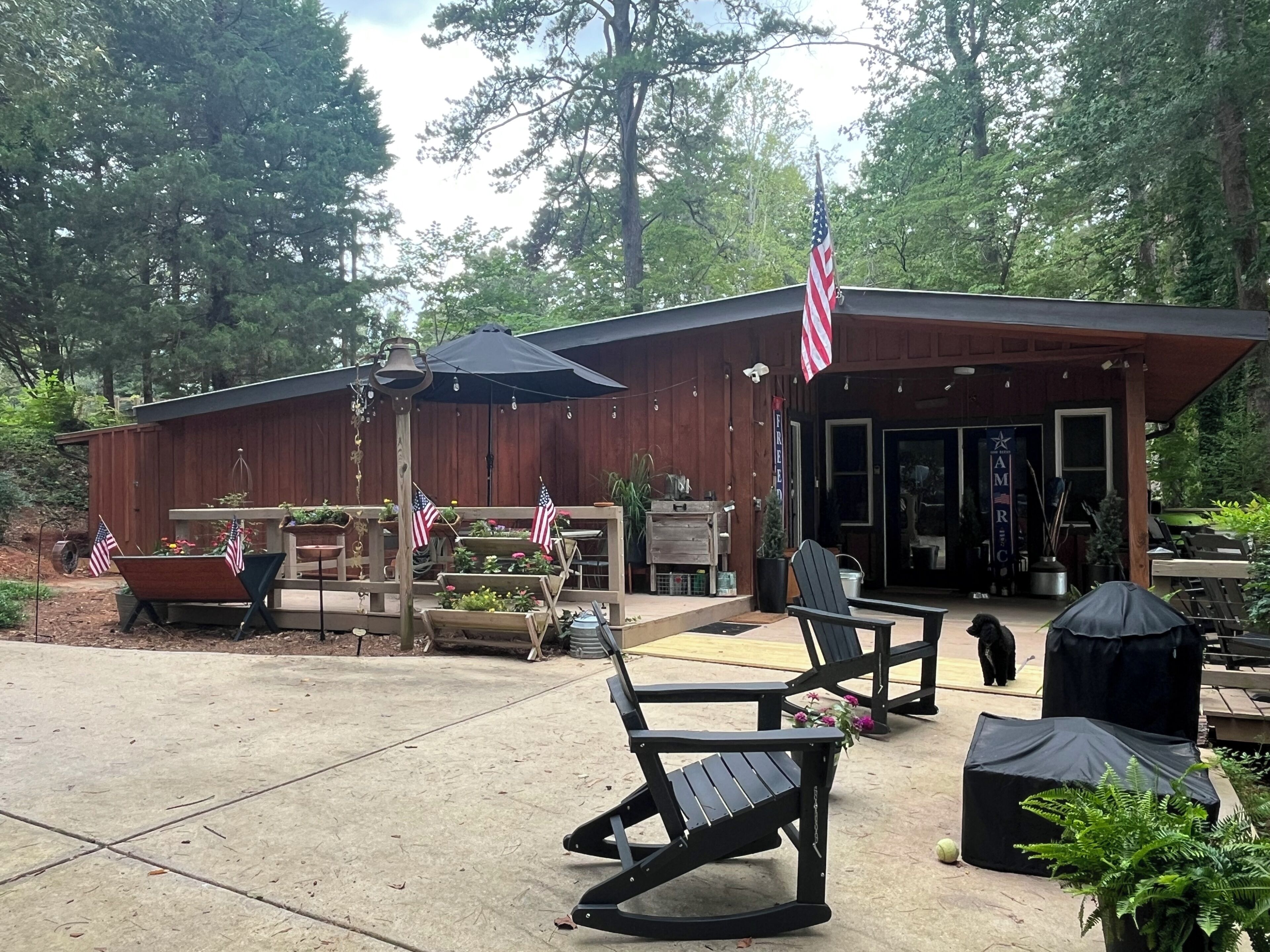 Une terrasse extérieure avec des meubles en bois, des drapeaux américains et un bâtiment sur lequel on peut lire l’inscription « AMRC ».