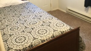 Een slaapkamer met een bed, een deur en een raam.