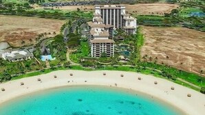 Un resort con acceso directo a la playa, varios edificios de gran altura y una playa de arena.