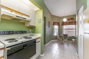 A compact kitchen with a stove, sink, and dining area. - Shorewalk 202/4625 - Bradenton-Condo 2 Bedroom/ 2 Bath, 5 miles from Anna Maria Island and near Img, maximum occupancy of 4 people. (Bradenton)