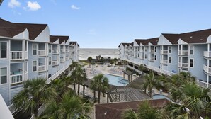 A hotel with multiple balconies overlooking a pool area and the beach. - Beach condo - 2 Balconies overlook the Ocean - Washer/Dryer Included (2301) (Galveston)