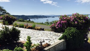 A stone pathway leading to a scenic overlook with a view of a lake and distant mountains.