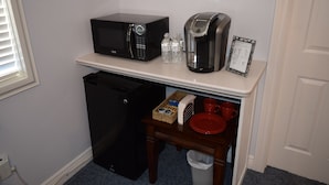 Una kitchenette equipada con microondas, cafetera y un refrigerador pequeño.