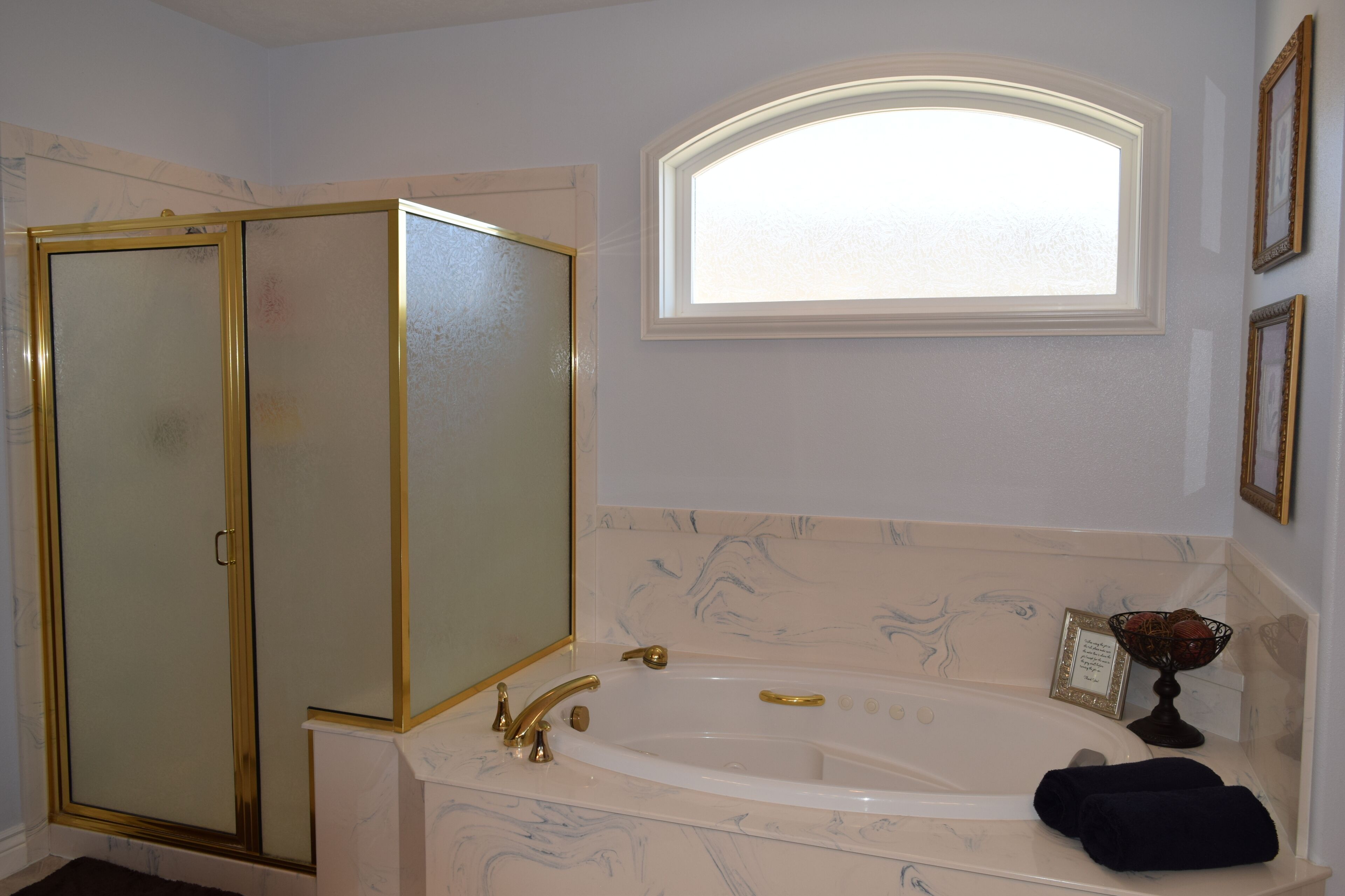 A bathroom with a bathtub, a glass-enclosed shower, and a vanity with a mirror.