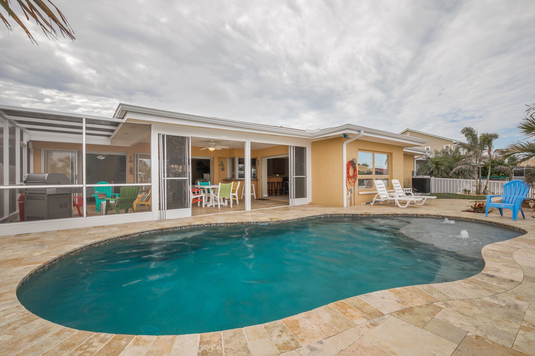 A modern house with a swimming pool, patio furniture, and a covered outdoor area.