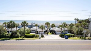 A residential street with houses, palm trees, and a clear view of the ocean. - Wanna Sea #202 - Newly Renovated Balcony! (Fernandina Beach)