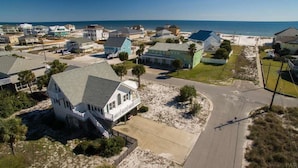 Un área residencial costera con casas, una playa y una vista despejada del océano.