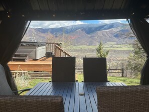 A deck with a table and chairs, overlooking a mountainous landscape. - Charming 3 Bedroom family house with hot tub on 2 acres panoramic views (Aspen)