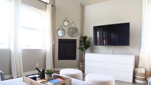 A modern bedroom with a bed, a TV, and a window with curtains. - Modern Mountain Getaway (Flagstaff)