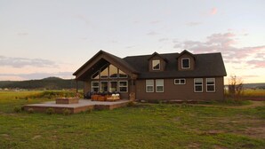 A two-story house with a large deck and a fireplace. - Modern Mountain Getaway (Flagstaff)