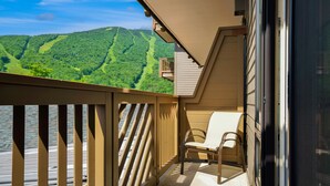 A balcony with a view of a forested mountain. - #374 | Studio | Remodeled Studio | 3rd Floor Mt Mansfield Views (Stowe)