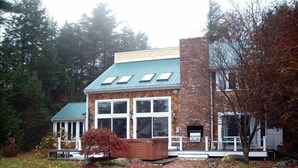 A two-story building with a brick facade and a green roof.