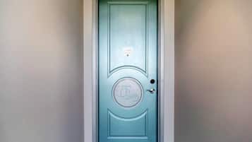 A teal door with a circular emblem and a small plaque above it.