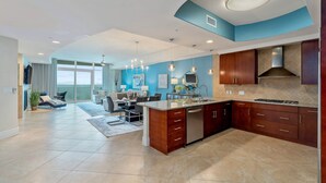 A modern kitchen with a central island, built-in appliances, and a dining area with a view.