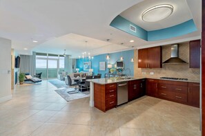 Una cocina moderna con una isla central, electrodomésticos integrados y un comedor con vistas.