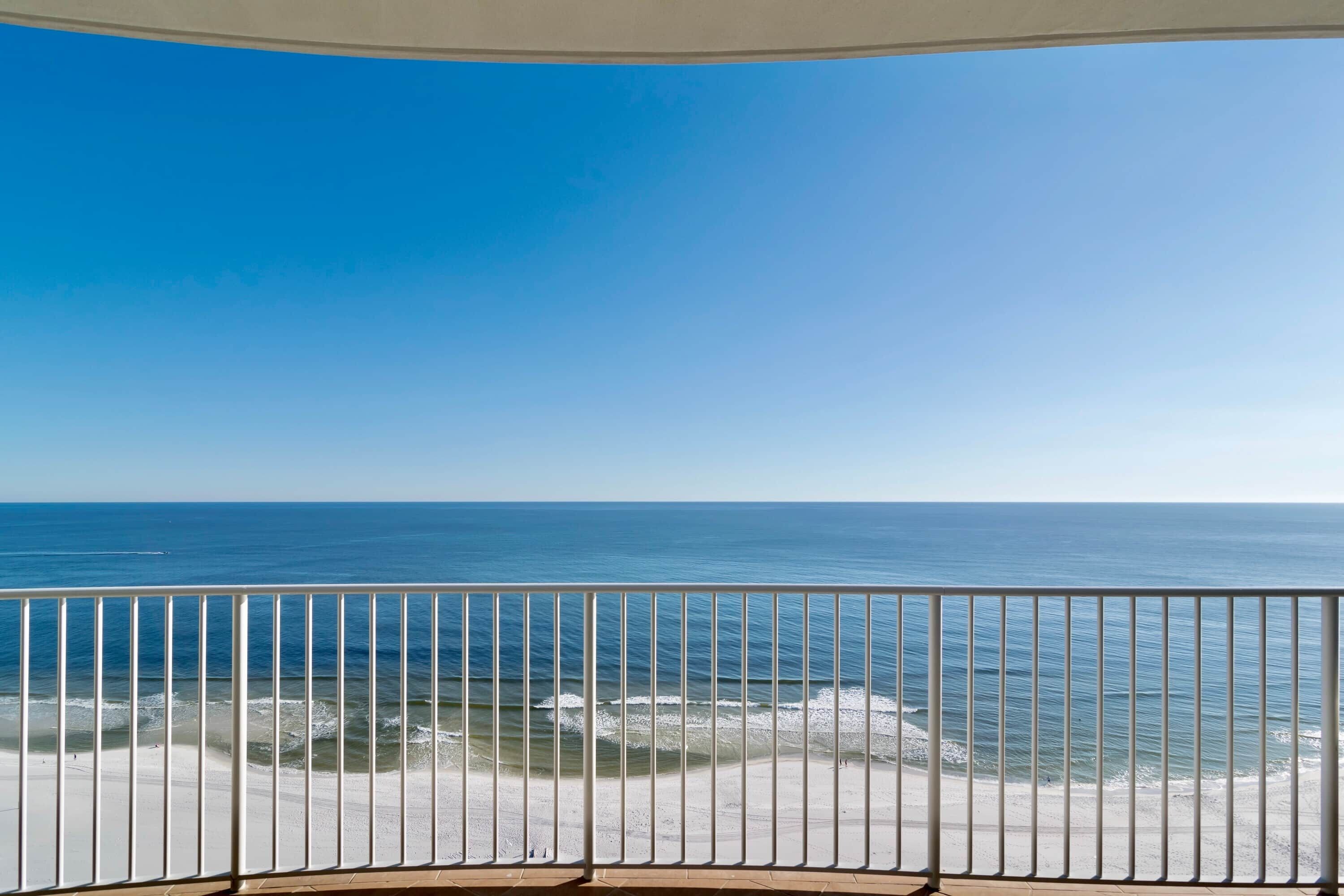 A balcony with a view of the ocean and beach.
