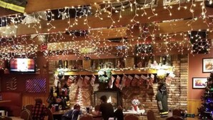 A restaurant with round tables and chairs, a brick fireplace, and Christmas decorations. - Amazing Updated Retreat with Fully Stocked All Seasons Game Room!  (St. Helen)