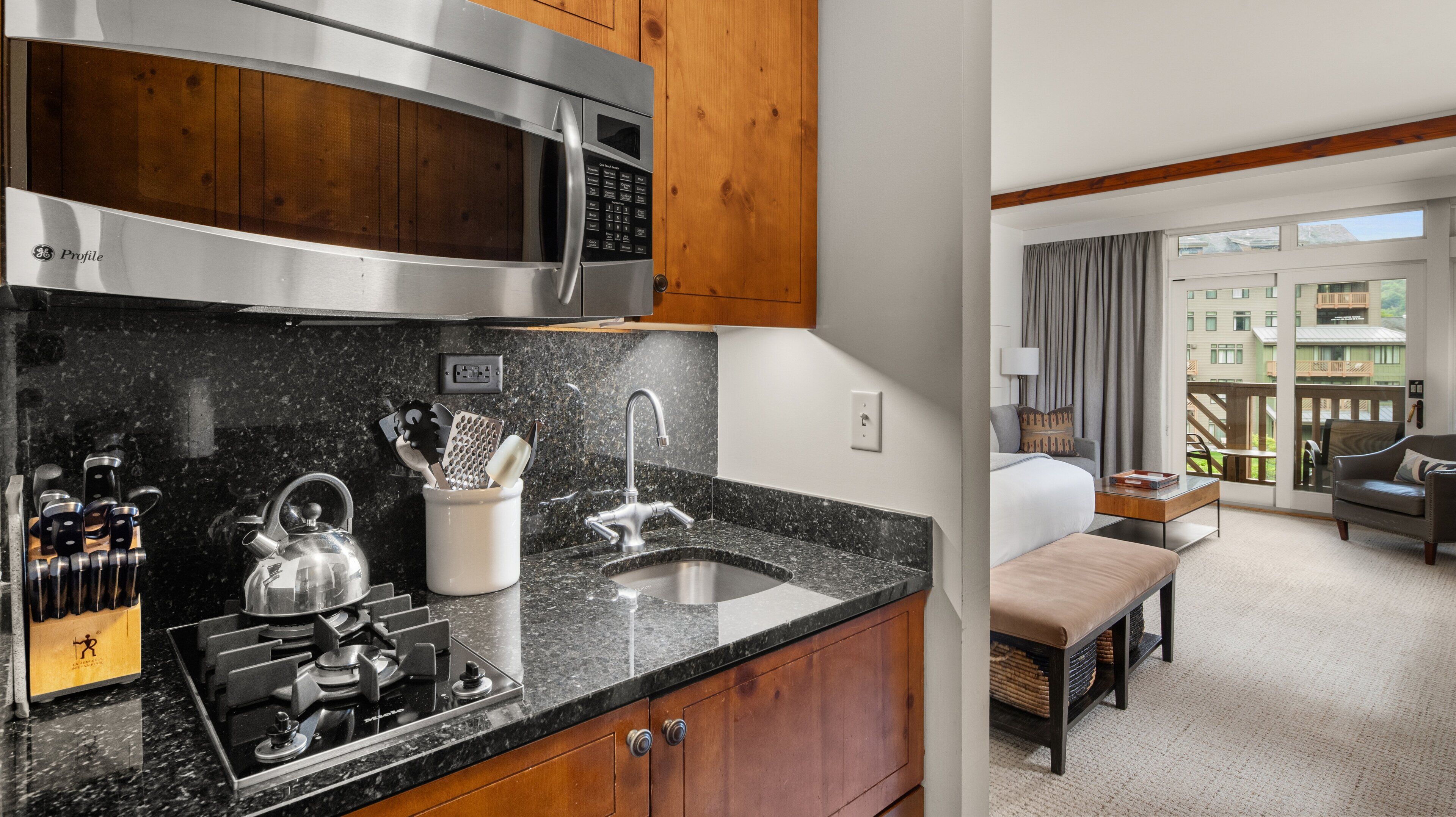 A modern kitchen with granite countertops, stainless steel appliances, and wooden cabinets.