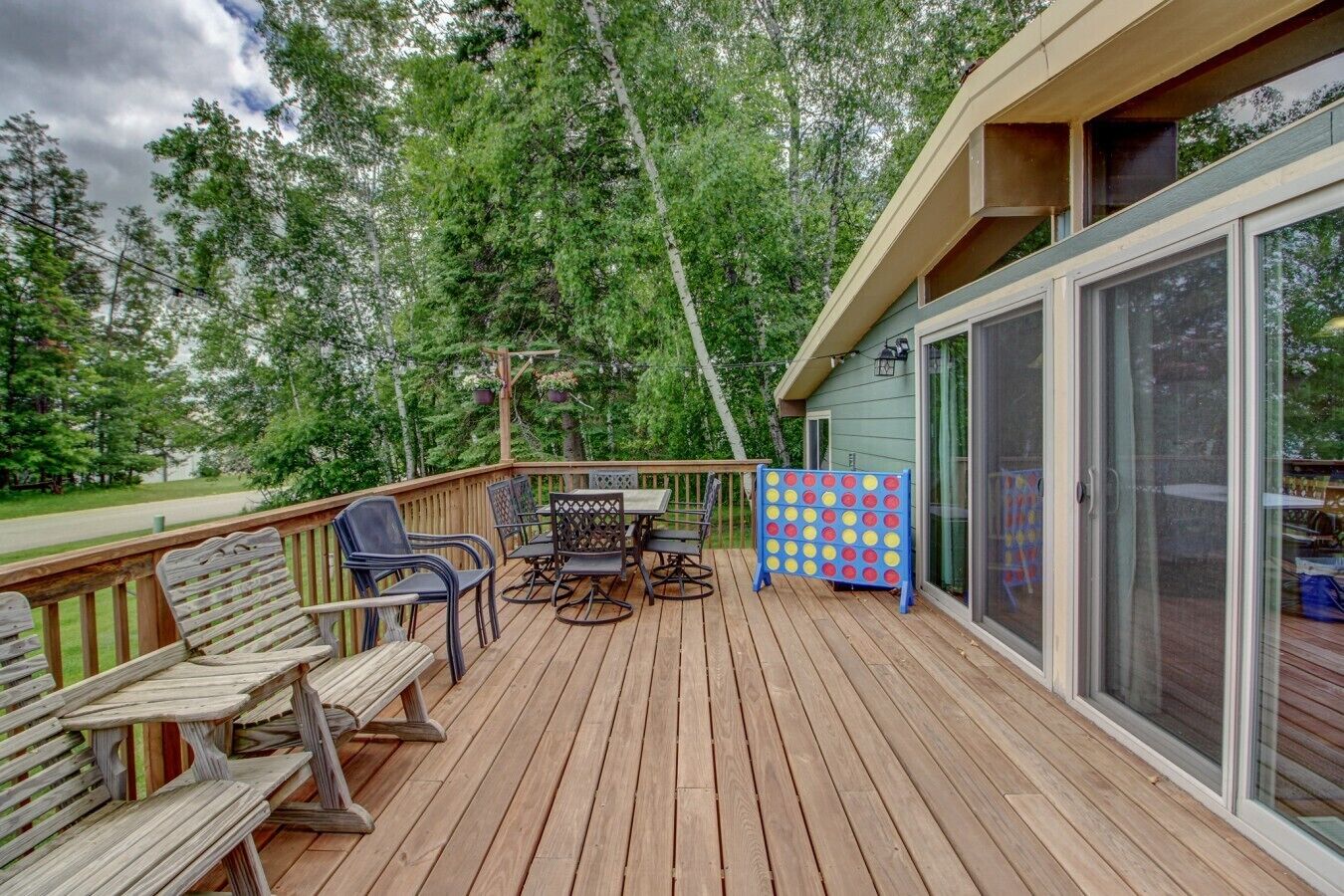 Une terrasse en bois avec des meubles d’extérieur, une table et des chaises.