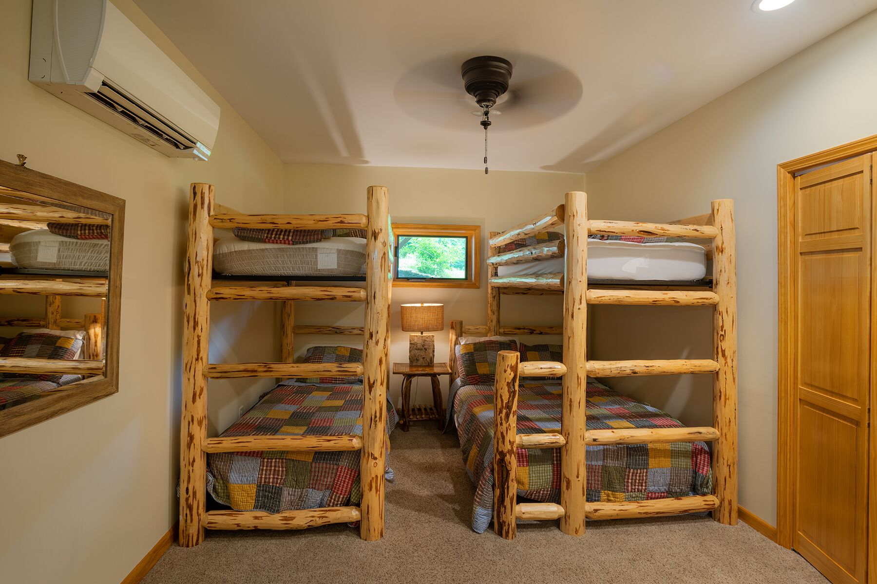 A room with bunk beds, a television, a lamp, and a ceiling fan.