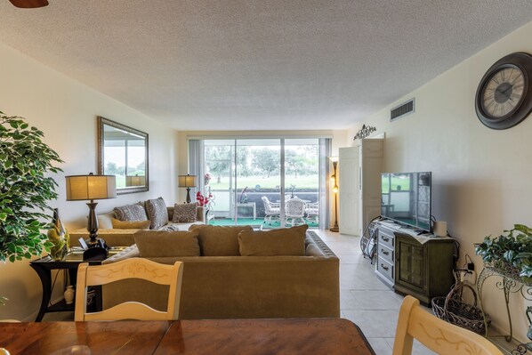 A living room with a sofa, television, and a dining area with a table.
