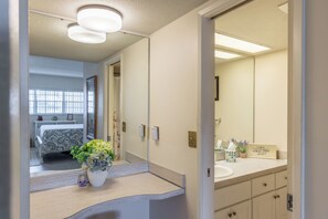A bathroom with a large mirror, a sink, and a vanity.