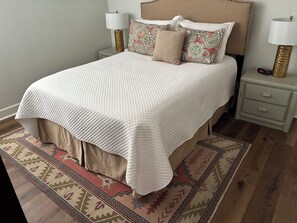 A bed with a white quilt, two bedside tables with lamps, and a patterned rug. - Fantastic Condo Within Walking Distance Of Football Stadium, Grove And Campus (Oxford)