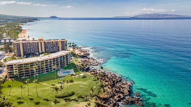 A resort with a large building, a pool, and a view of the ocean. - 104 - Lovely Ground Floor Direct Oceanfront + Larger Lanai (Kihei)