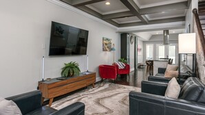 A modern living room with a flat-screen TV, red and black sofas, a wooden console, and a marble-patterned rug. -  Luxe Three floors. Four bedrooms each with private full bath  Garage Parking (Washington)
