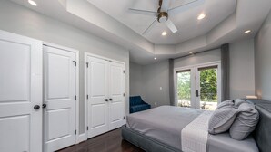 A bedroom with a bed, a ceiling fan, and a view of the outdoors through a sliding door. -  Luxe Three floors. Four bedrooms each with private full bath  Garage Parking (Washington)