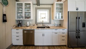 Una cocina moderna con armarios blancos, un refrigerador de acero inoxidable y un lavavajillas integrado.