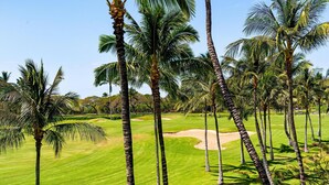Ein Golfplatz mit Palmen und einem gepflegten Grün.