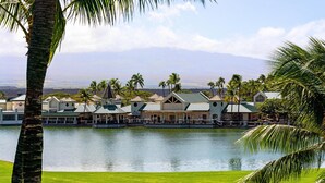 Ein Resort mit See, Palmen und Blick auf ferne Berge.