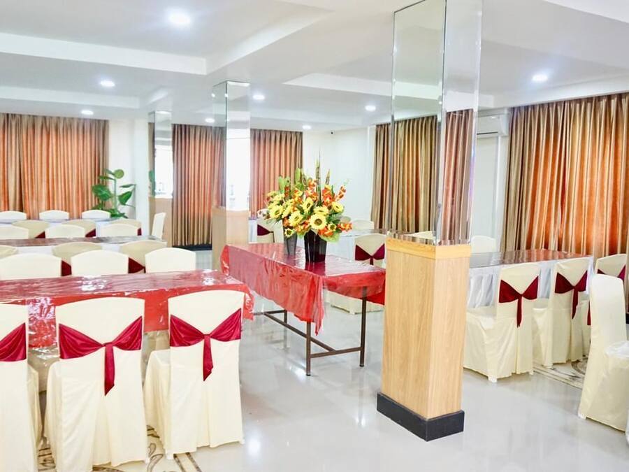 A conference room with tables and chairs, a podium, and curtains.