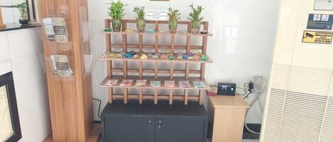 A reception area with a wooden desk, a security camera, and a display of colorful items.