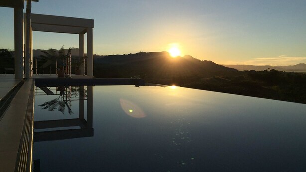 A serene sunset view from a balcony with a clear sky and distant mountains. - Fiji Luxury Pool Villa (Lautoka)