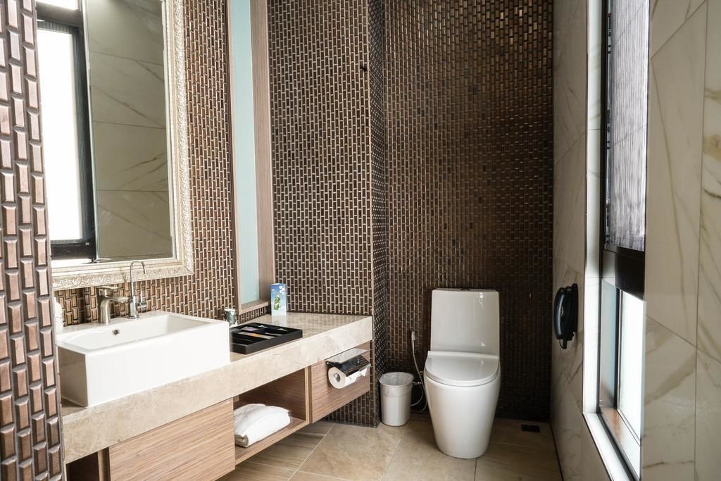 A bathroom with a sink, mirror, toilet, and shower.