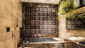 A luxurious bathroom with a marble vanity, a large cushioned wall panel, and a built-in bathtub. - Shu Lan Motel (Nantou)