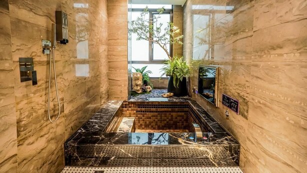 A luxurious bathroom with marble walls, a black marble sink, and a small indoor garden. - Shu Lan Motel (Nantou)