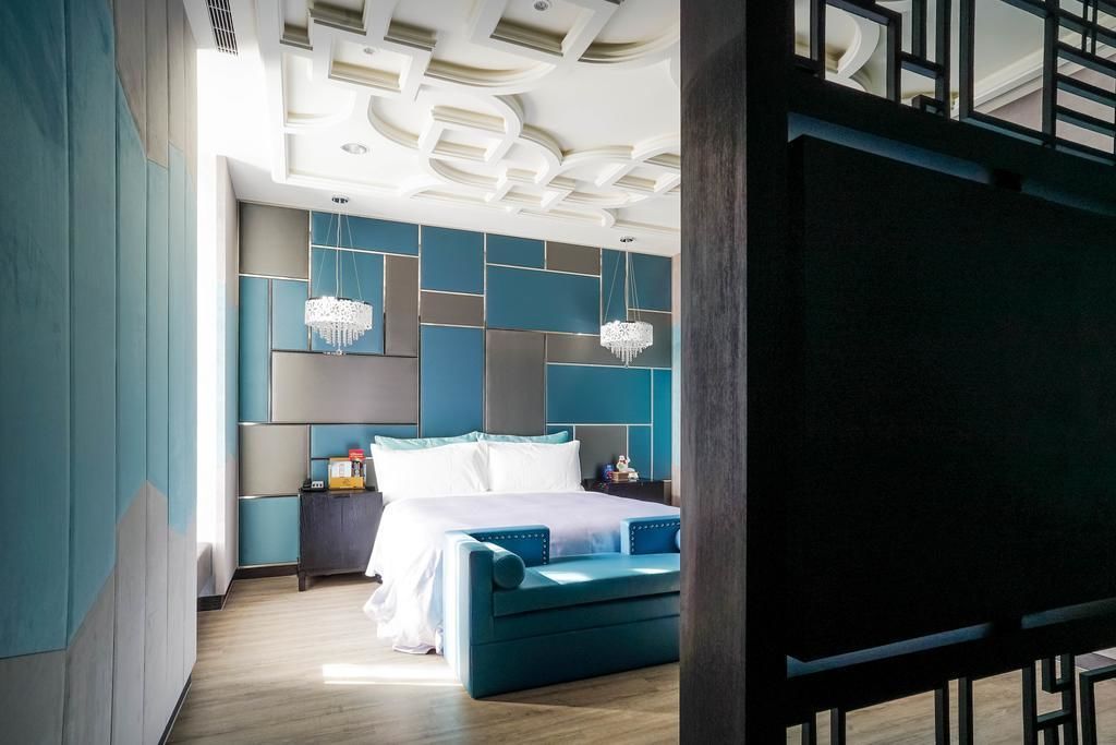 A modern bedroom with a large bed, a nightstand, and a dresser.