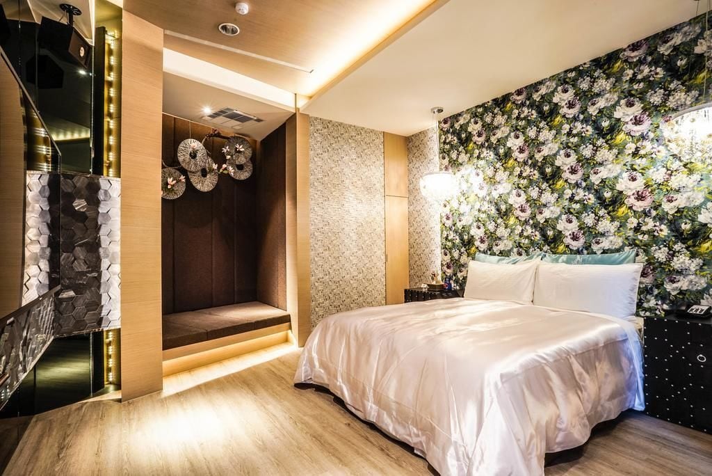 Un dormitorio moderno con una cama grande, un banco empotrado, un muro decorativo y una escalera.