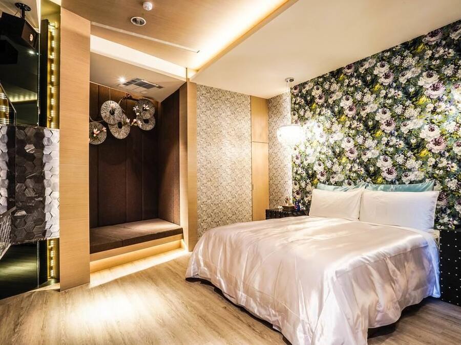 Un dormitorio moderno con una cama grande, un banco empotrado, un muro decorativo y una escalera.