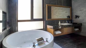 A modern bathroom with a freestanding bathtub, a large mirror, and a vanity with a marble countertop.