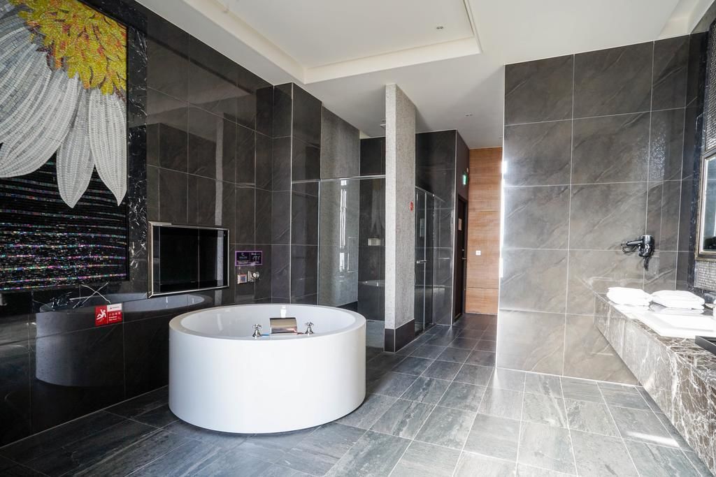 A modern bathroom with a large bathtub, a separate shower area, and a vanity with a sink.