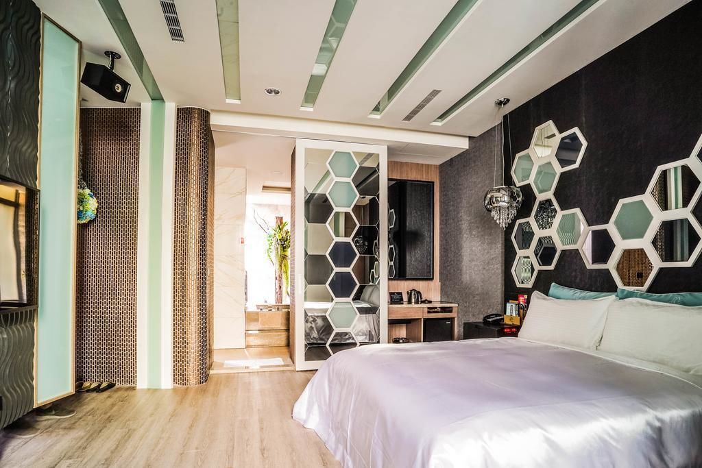Ein modernes Hotelzimmer mit einem großen Bett, einem Schreibtisch und einer Sitzecke.
