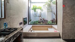 A modern bathroom with a large window, a built-in hot tub, and a small garden view. - Shu Lan Motel (Nantou)