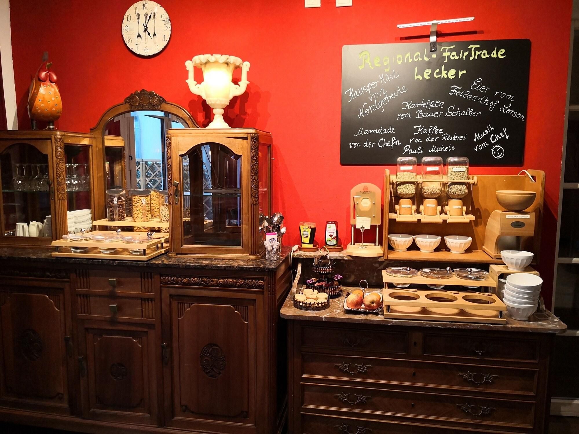 A buffet setup with various food items and a chalkboard menu listing regional fair trade products.