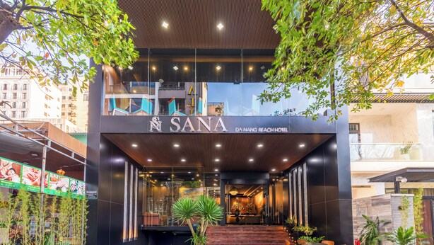 The entrance of Da Nang Beach Hotel with a modern design, featuring a reception area with a staircase leading to the upper floors. - Sana Danang Beach Hotel (Da Nang)